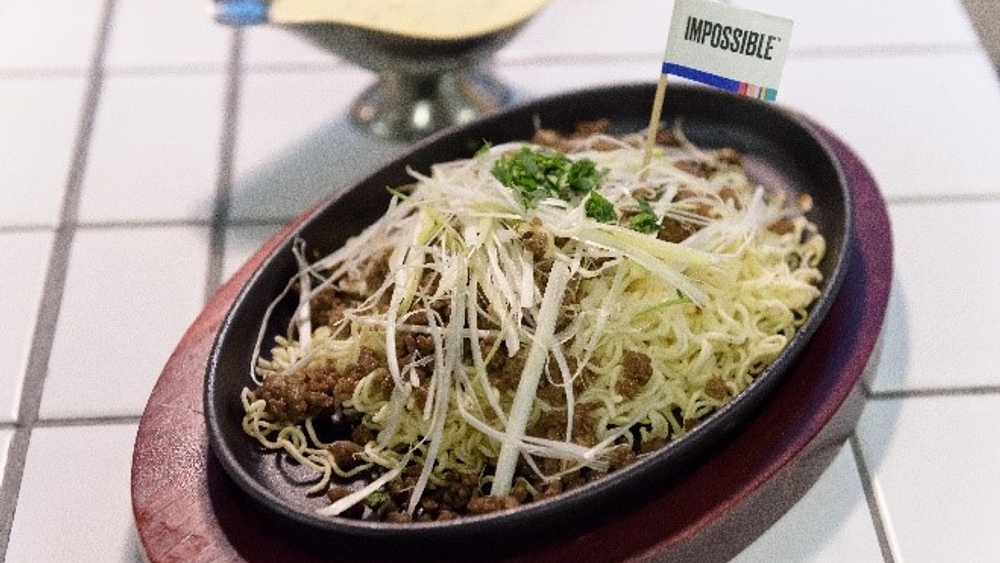 相片: Impossible Foods與香港餐廳合作創製多款本地化佳餚，Impossible冬菜蒸植物肉餅煲仔飯、Impossible 鐵板蔥花植物肉芝士汁撈公仔麵只是其中兩款美食。 